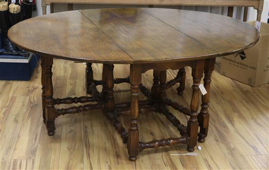 An early 18th century style gateleg oak dining table W.186cm